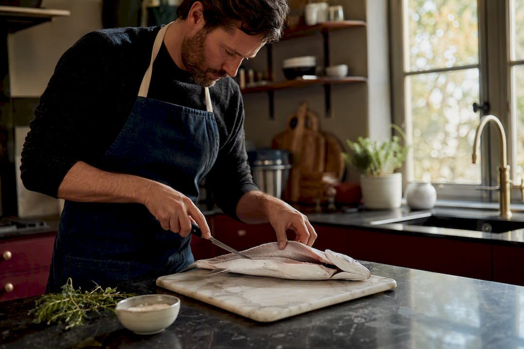 Close overhead of fish filleting knife on wooden board