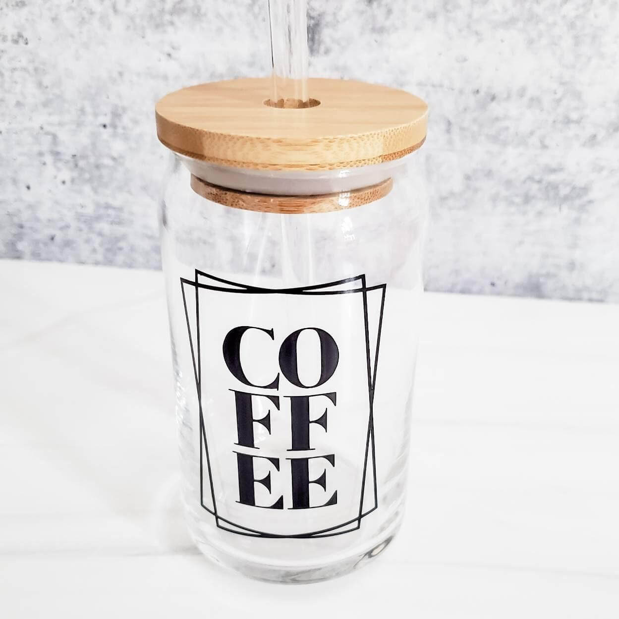 Clear glass can cup for coffee lovers with black "COFFEE" text and bamboo lid.