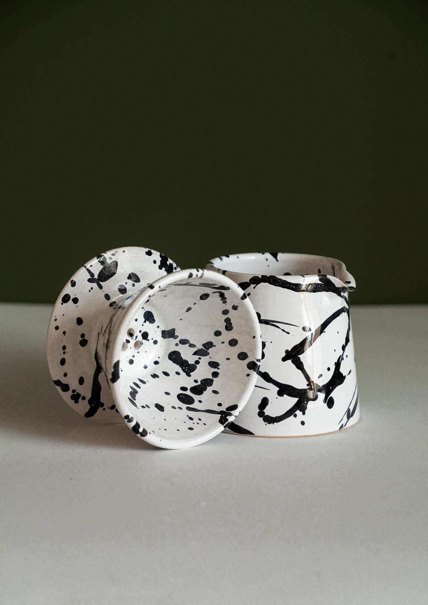 Handmade ceramic pour over coffee set featuring black and white splatter design. Perfect for brewing coffee.