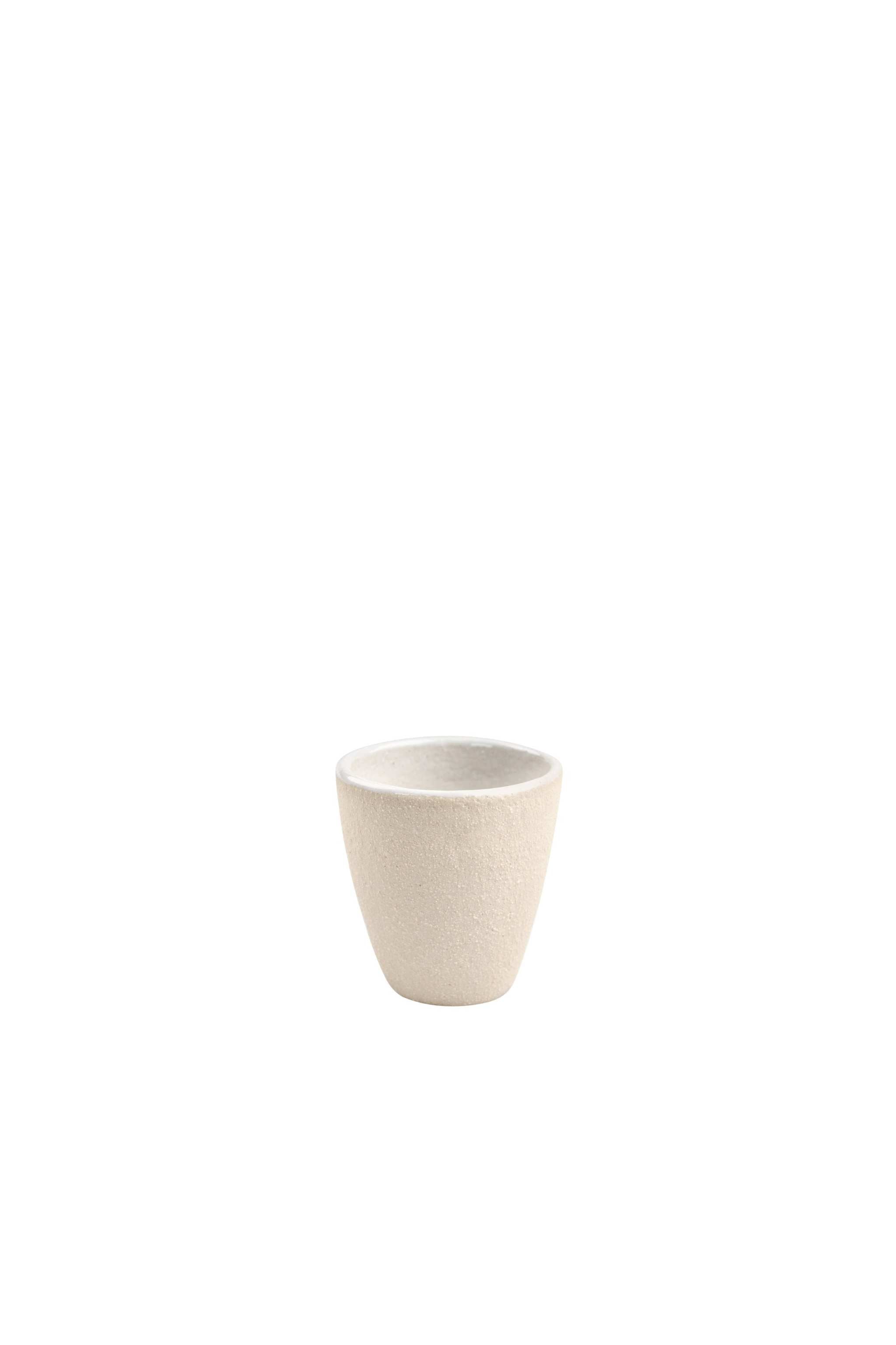 Handmade stoneware espresso cup with exposed clay and shiny glaze, perfect for serving espresso.