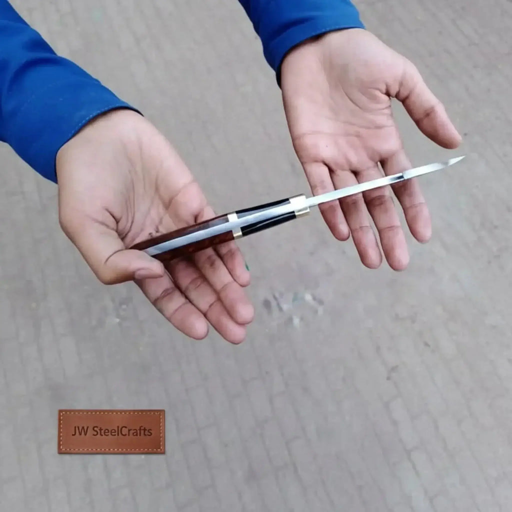 Person holding an 11.5 inch Damascus steel fillet knife with a two-tone wood handle by JW SteelCrafts.