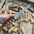 Hand-forged damascus fish fillet knife in a hand, showcasing its flexible blade and rosewood handle on wooden backdrop.