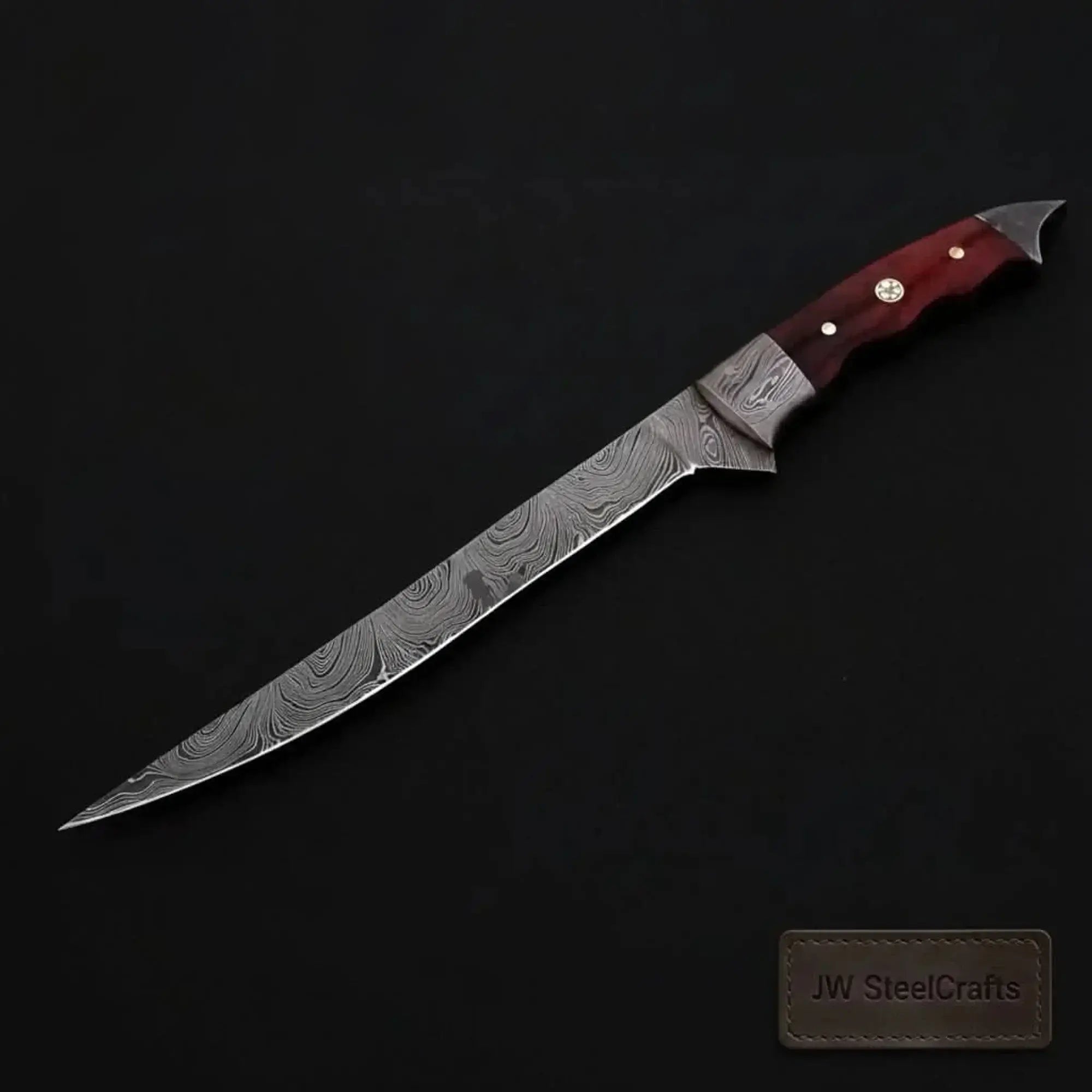 Handmade Damascus fillet knife with flexible blade and hardwood handle on a dark background.