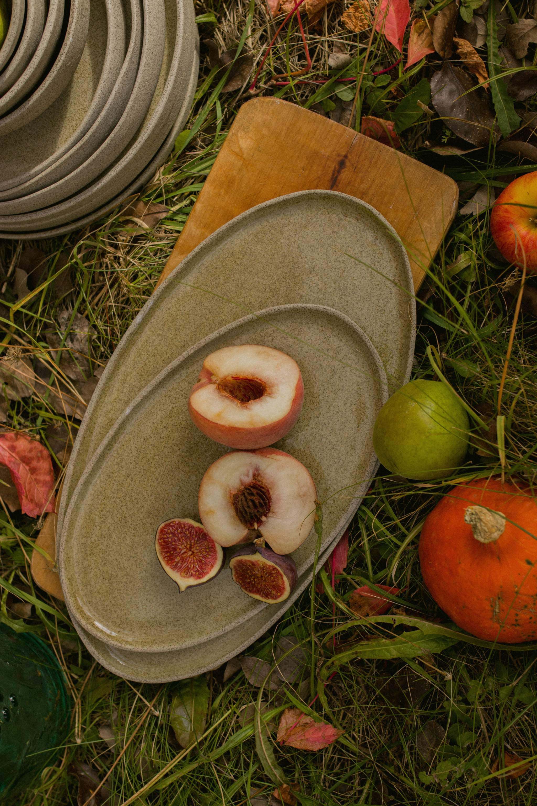 Handmade stoneware serving platter 'Concrete' with fresh peaches and figs on a wooden board.