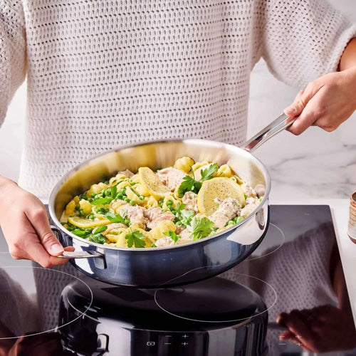 Cooking pasta with chicken and herbs in a 5-ply stainless steel sauté pan on an induction stove.