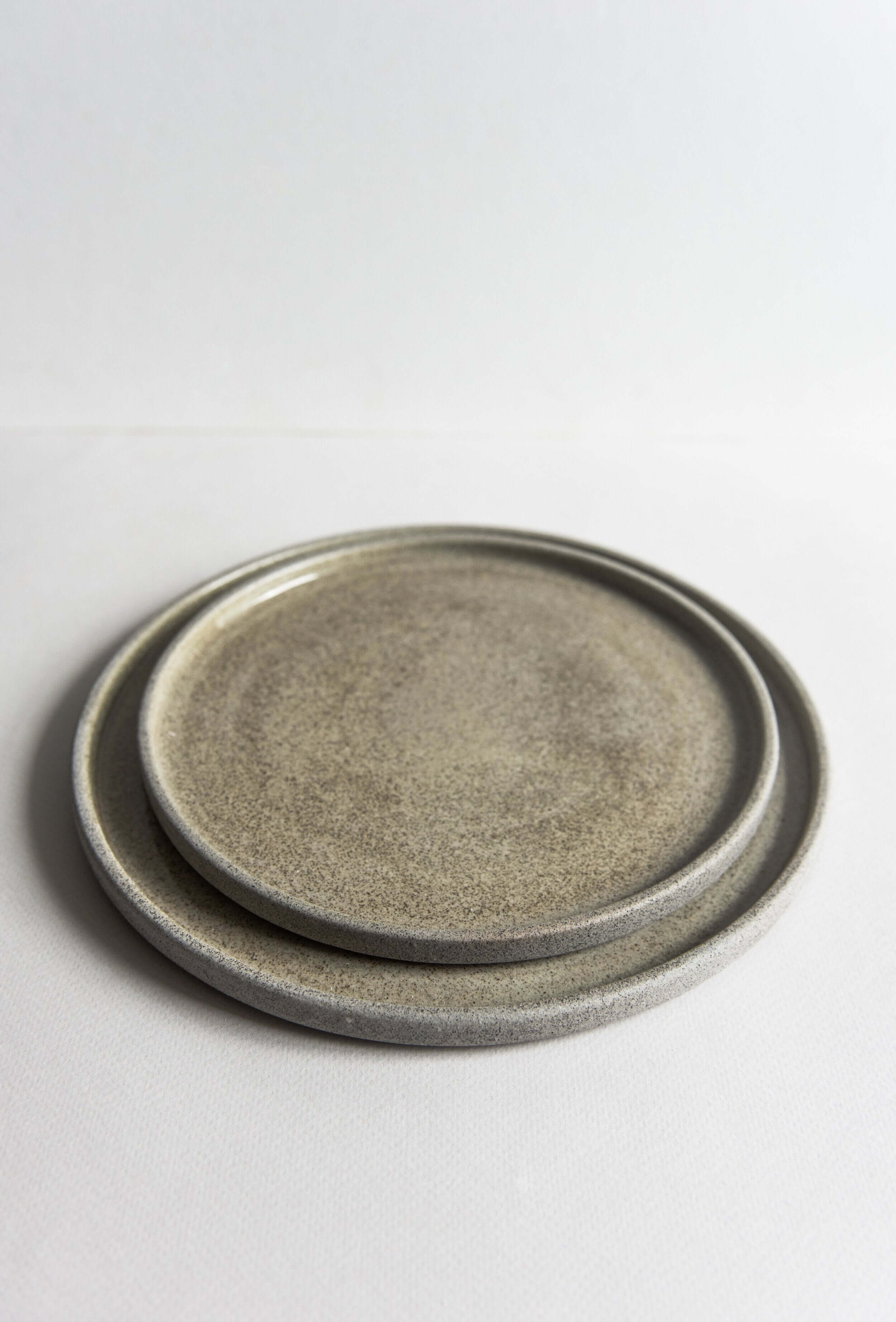Stoneware dinner plates "Concrete" with rustic texture and glossy finish, showcasing unique design and functionality.
