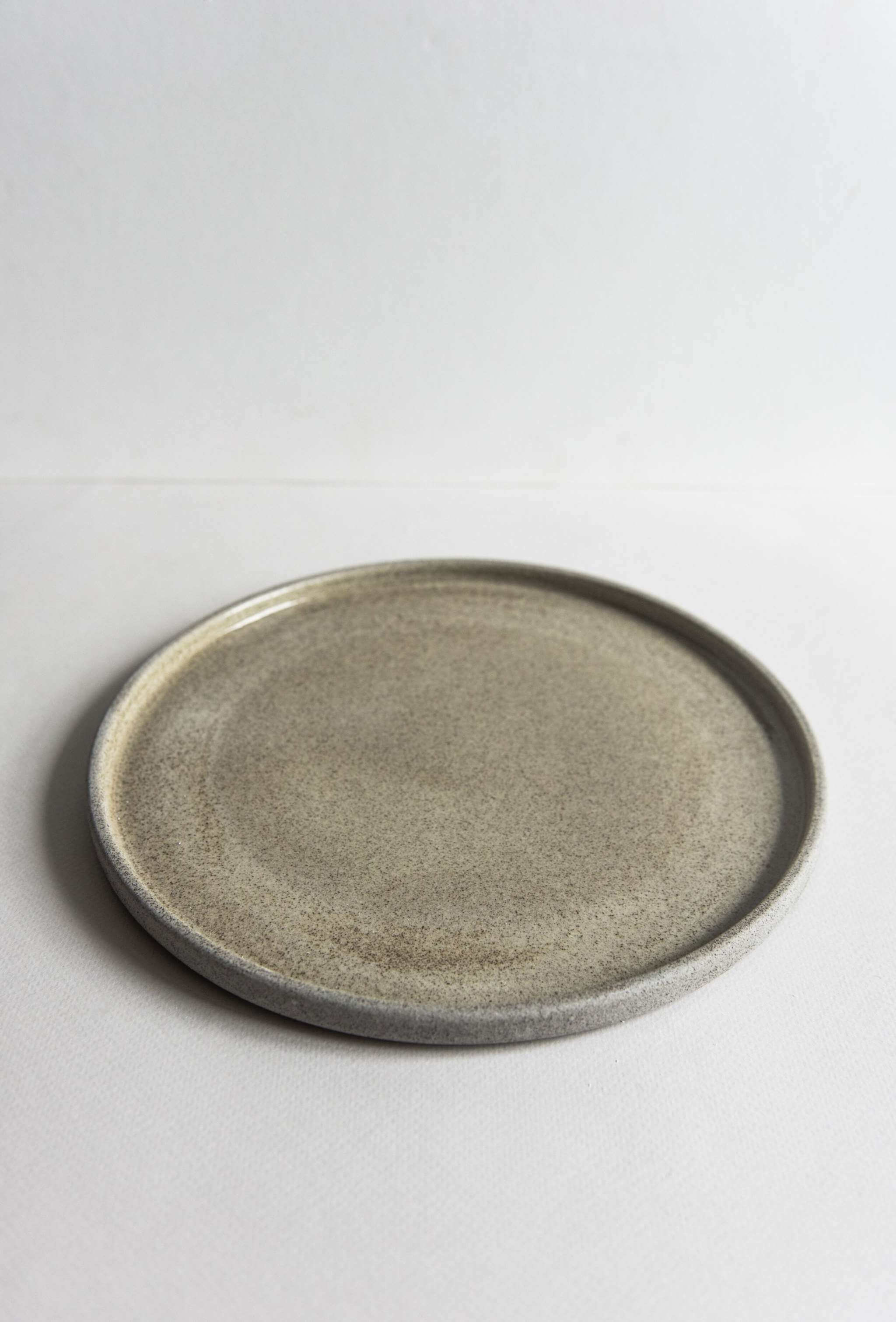 Stoneware dinner plates concrete, featuring a rustic gray finish with a glossy interior and rough-textured exterior.