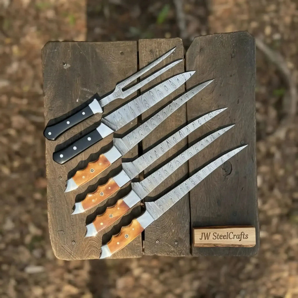 Handmade Damascus boning knife set displayed on a rustic wooden table, showcasing black and orange resin handles.