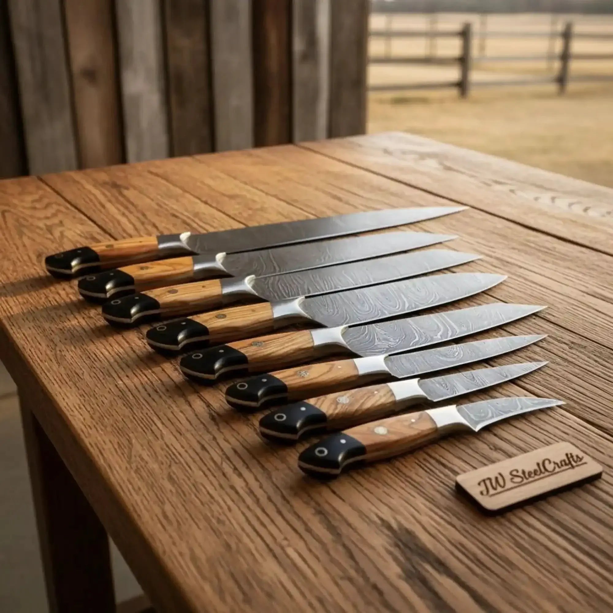 8-piece damascus fillet knife set displayed on a wooden table with olive wood and black resin handles.