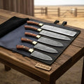 Five piece Damascus kitchen knife set laid out on a work surface