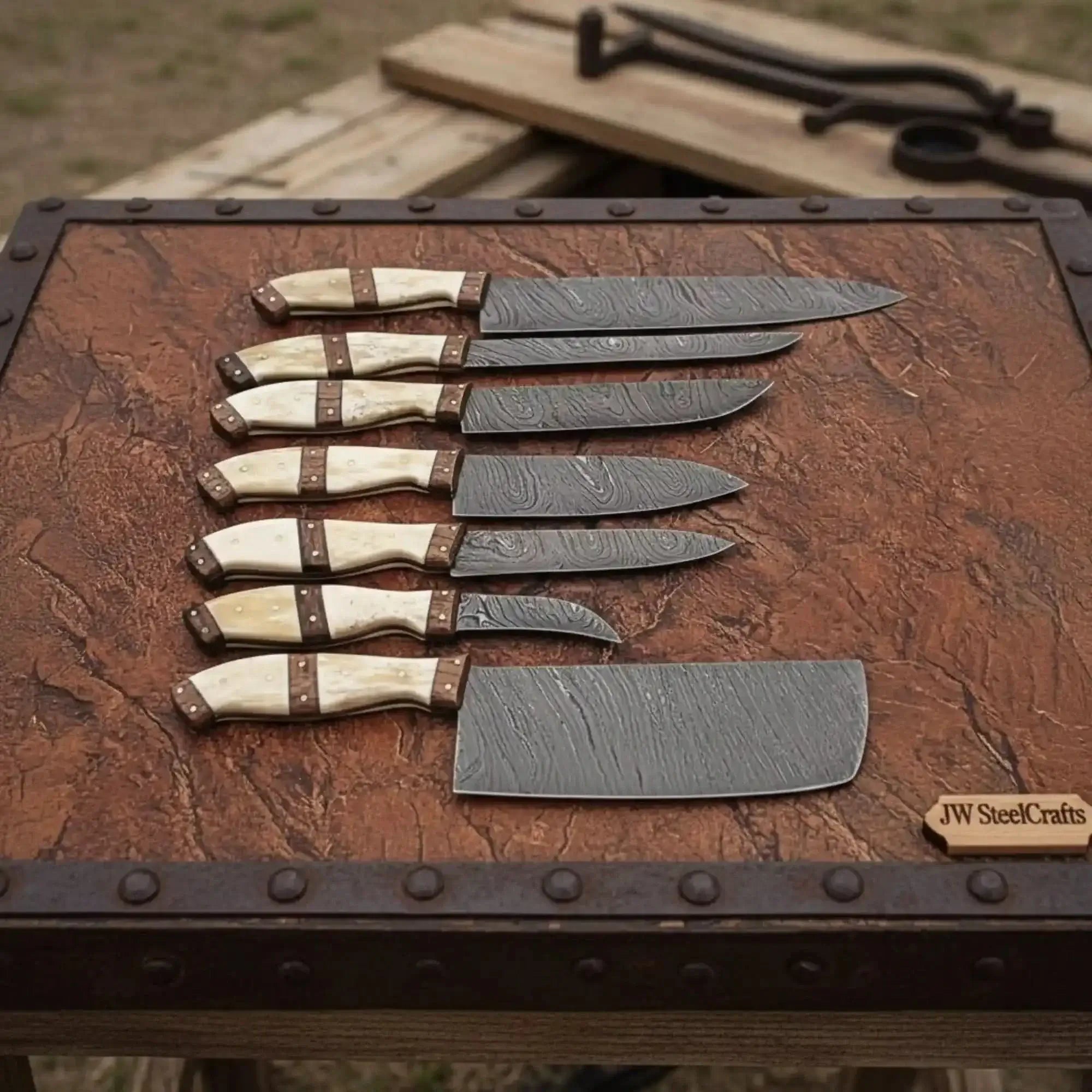 7-piece Damascus kitchen knife set with natural bone handles displayed on a wooden surface.